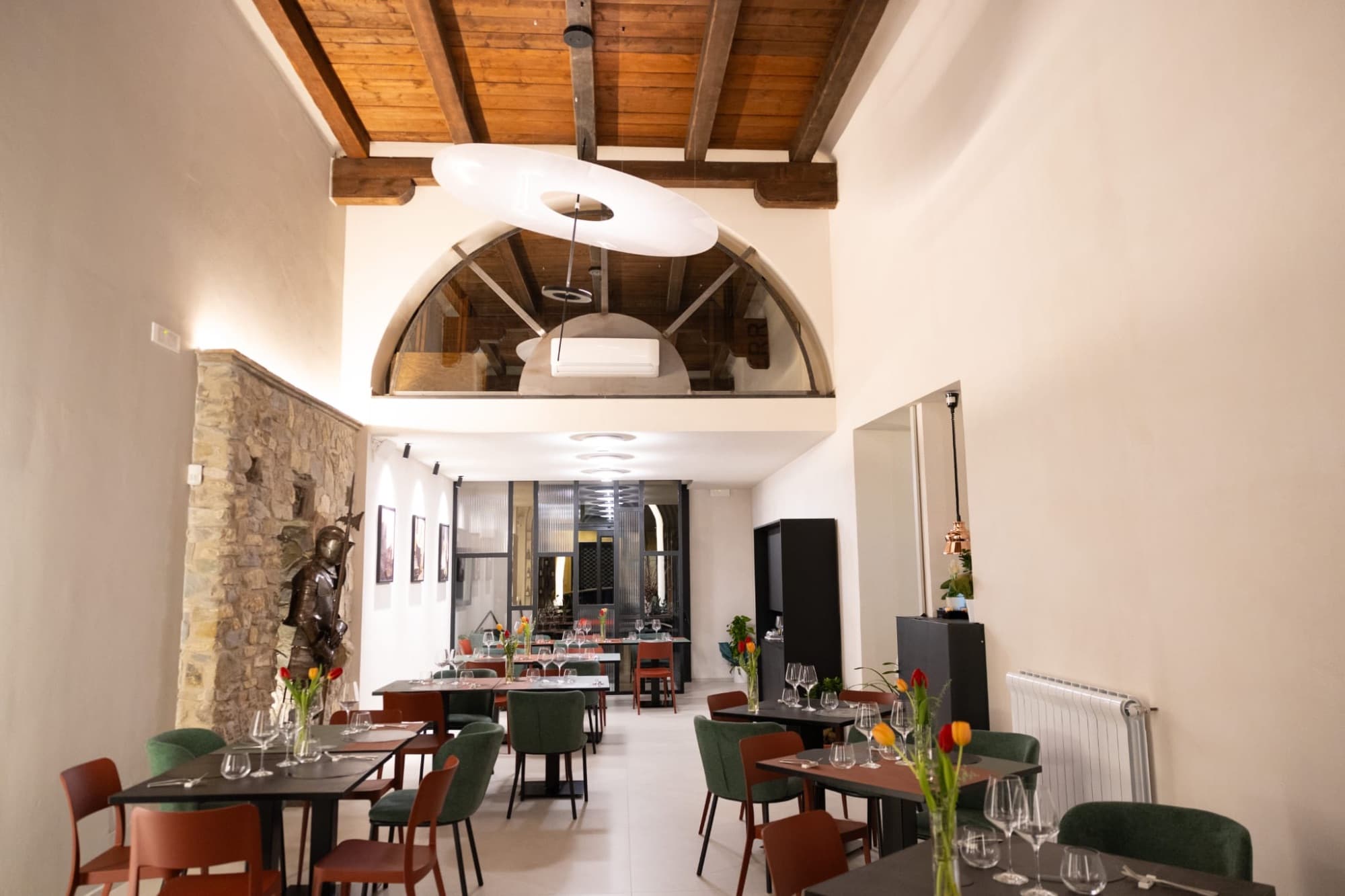 La sala principale con soffitto in legno e parete in pietra